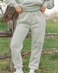 Person wearing a light gray 'Perfect Life' tracksuit in an outdoor setting.