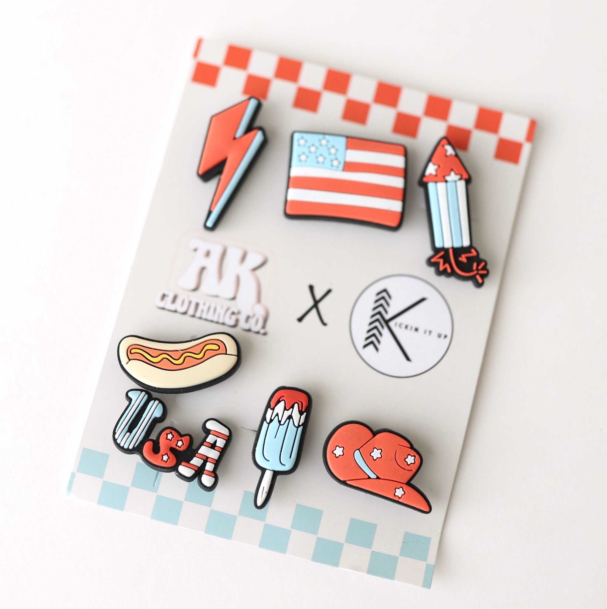 Set of colorful pins on a checkered card with visible brand logos.