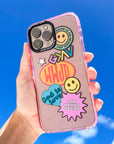 Phone case with colorful designs and text held against a blue sky