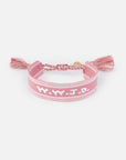 Dusty rose WWJD woven bracelet with white embroidered lettering, braided ties, and tassel ends