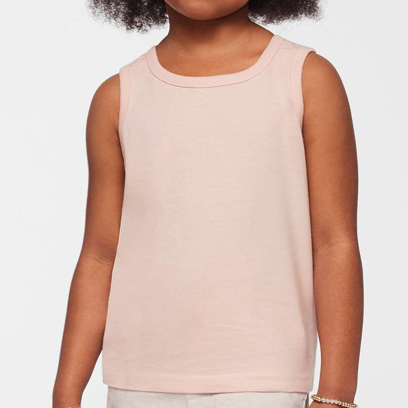 Young girl wearing a light pink sleeveless top against a white background