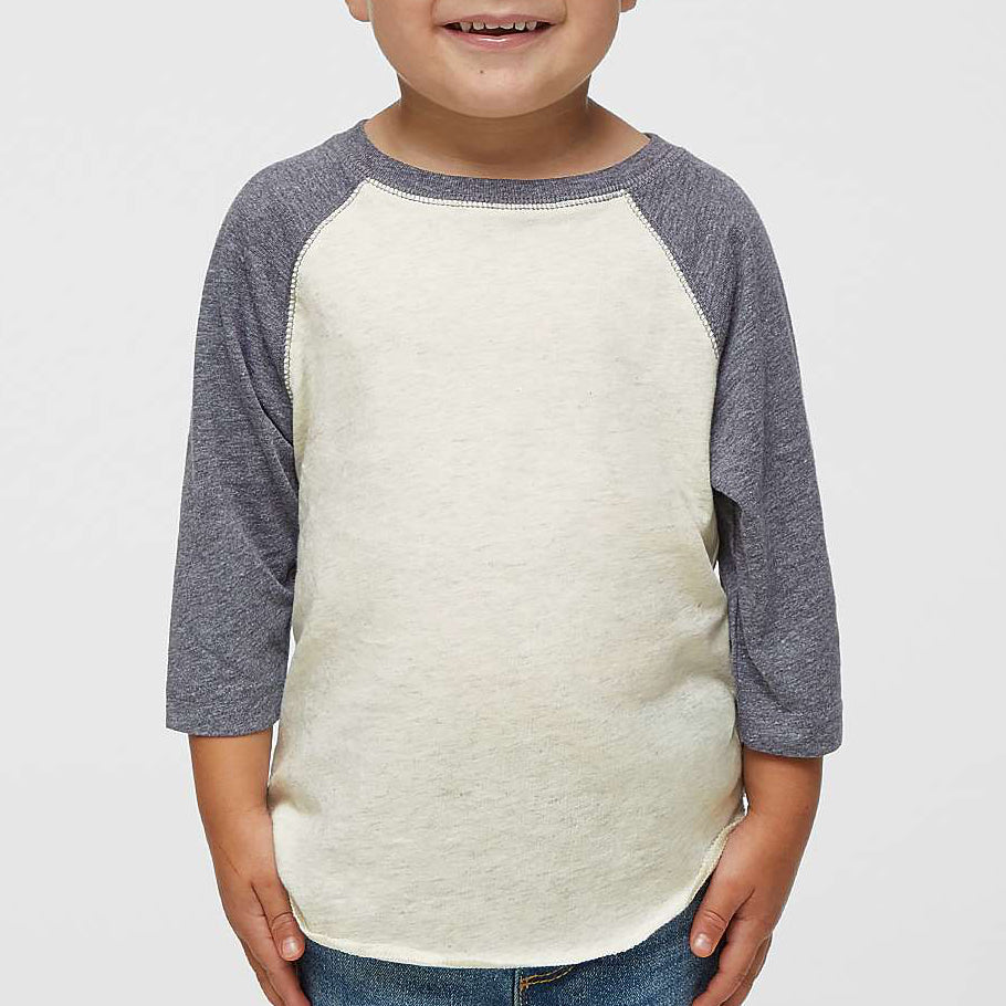 Child wearing a gray and white baseball shirt on a plain background