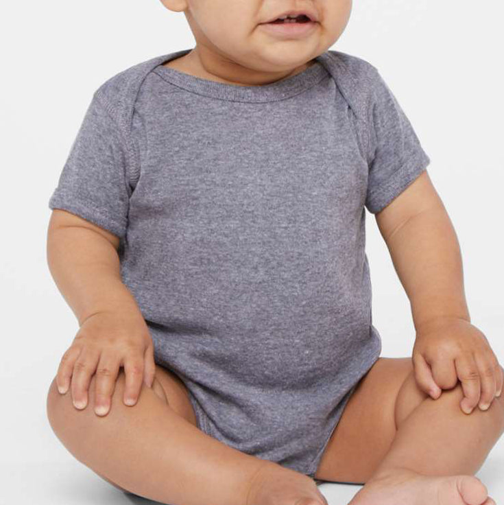 Smiling baby wearing a gray Rabbit Skins 4400 Infant Baby Rib Bodysuit and matching beanie, seated on a light background, showcasing the soft cotton fabric and comfortable fit.
