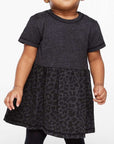 Child wearing a dark gray dress with a leopard print skirt on a white background