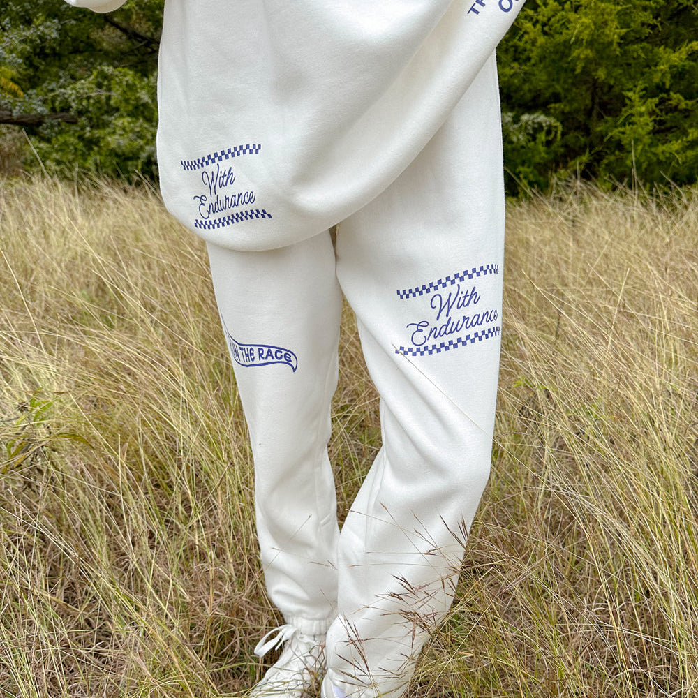Person wearing a white outfit with text in a natural setting