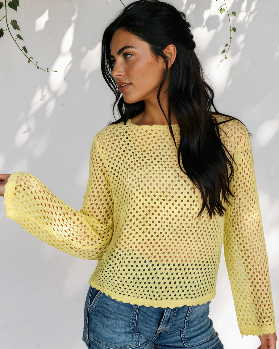 Model wearing the yellow Felicity open-knit top, showing its long sleeves and flared cuffs from the side.