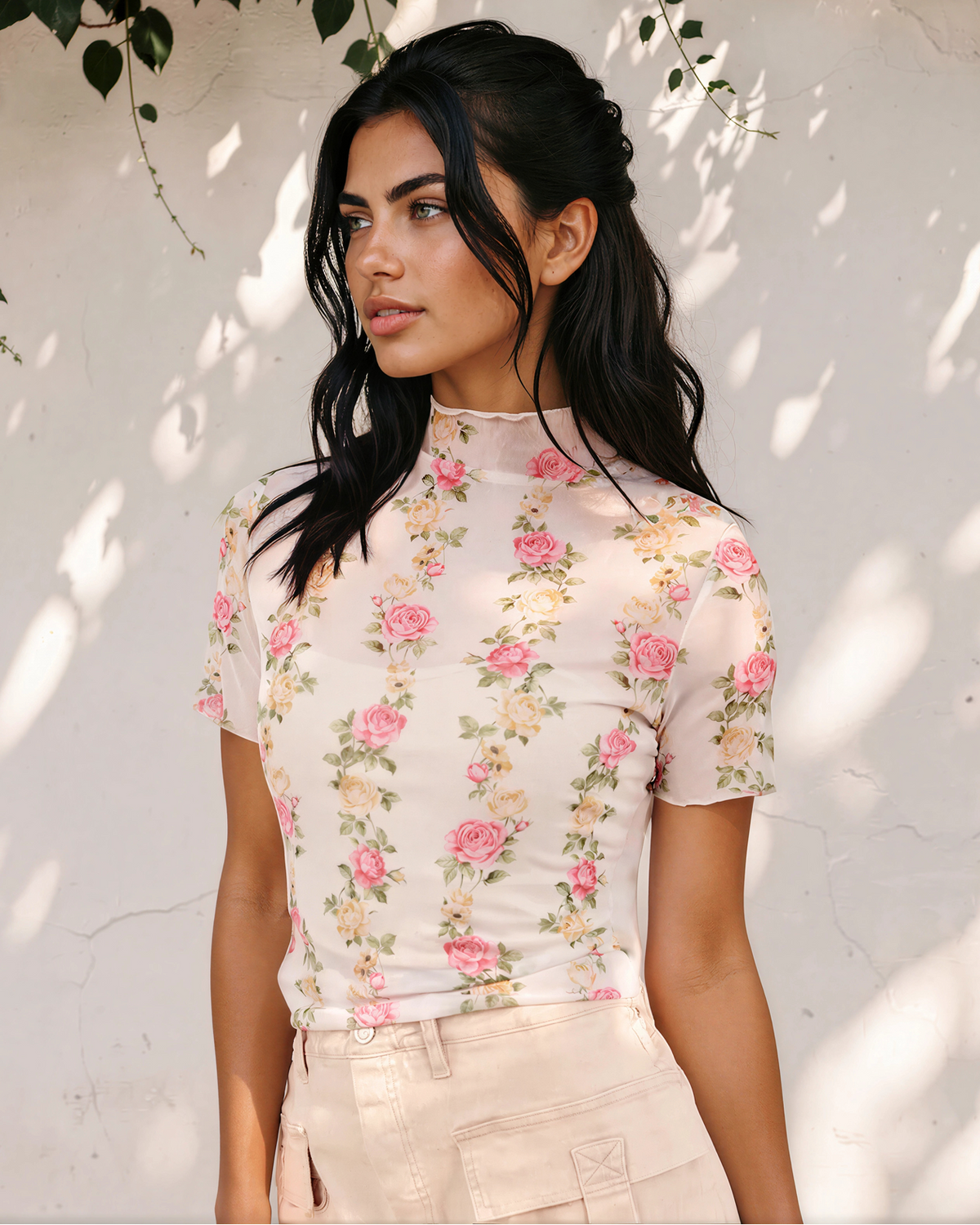 Close-up of the Millie mesh top featuring pink flowers, green foliage, a mock neckline, and short sleeves.