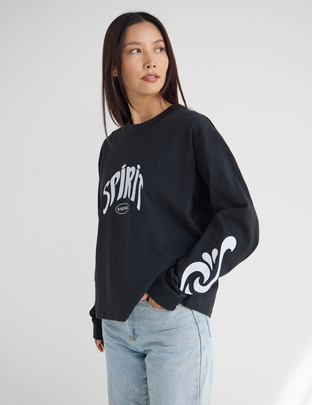Front view of the Spirit Is Moving heavyweight tee showing white lettering and flowing sleeve graphics