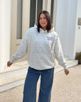 Model wearing the ivory Talk to God Allover Wildflower Unisex Hoodie with blue jeans