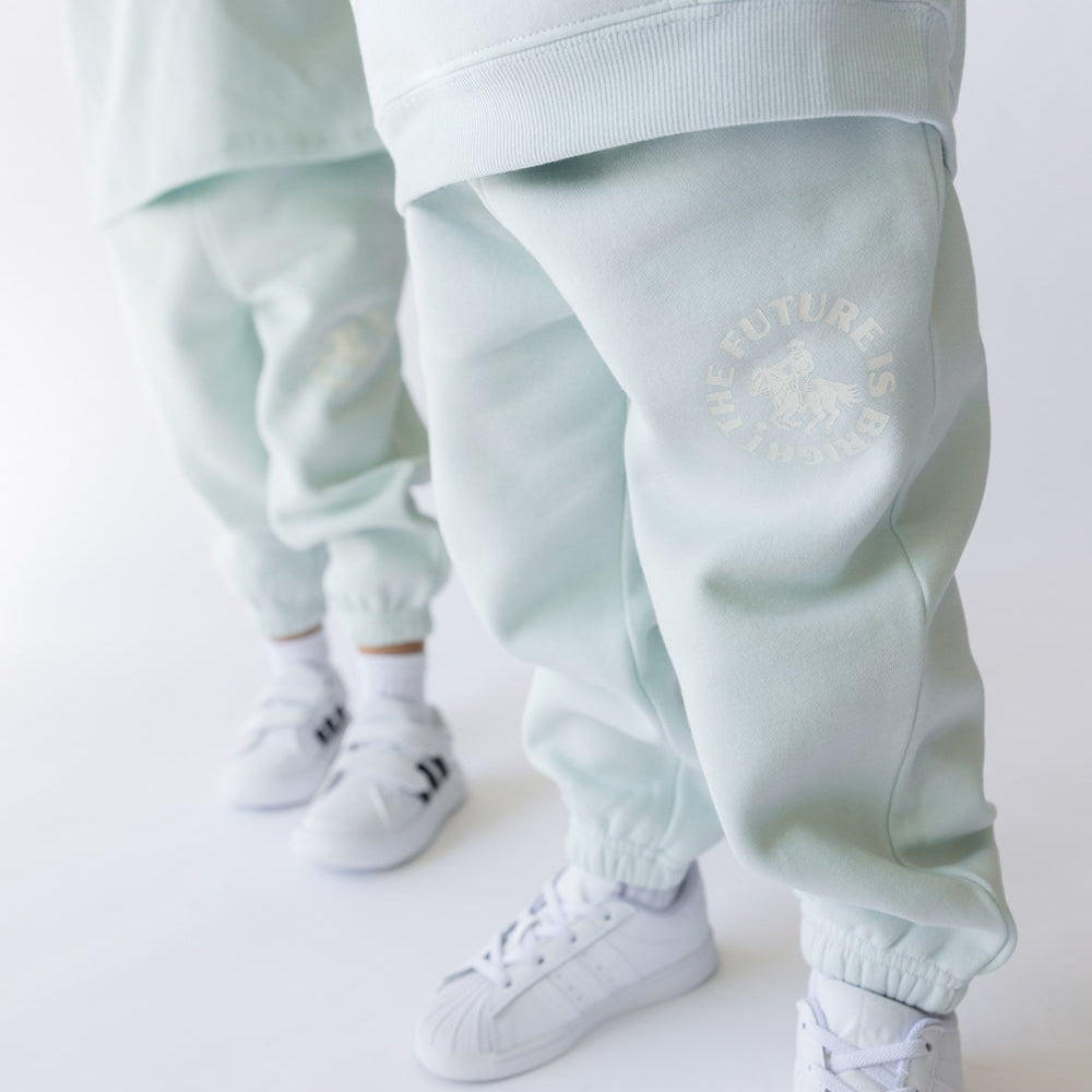 Light blue tracksuit with white sneakers on a white background