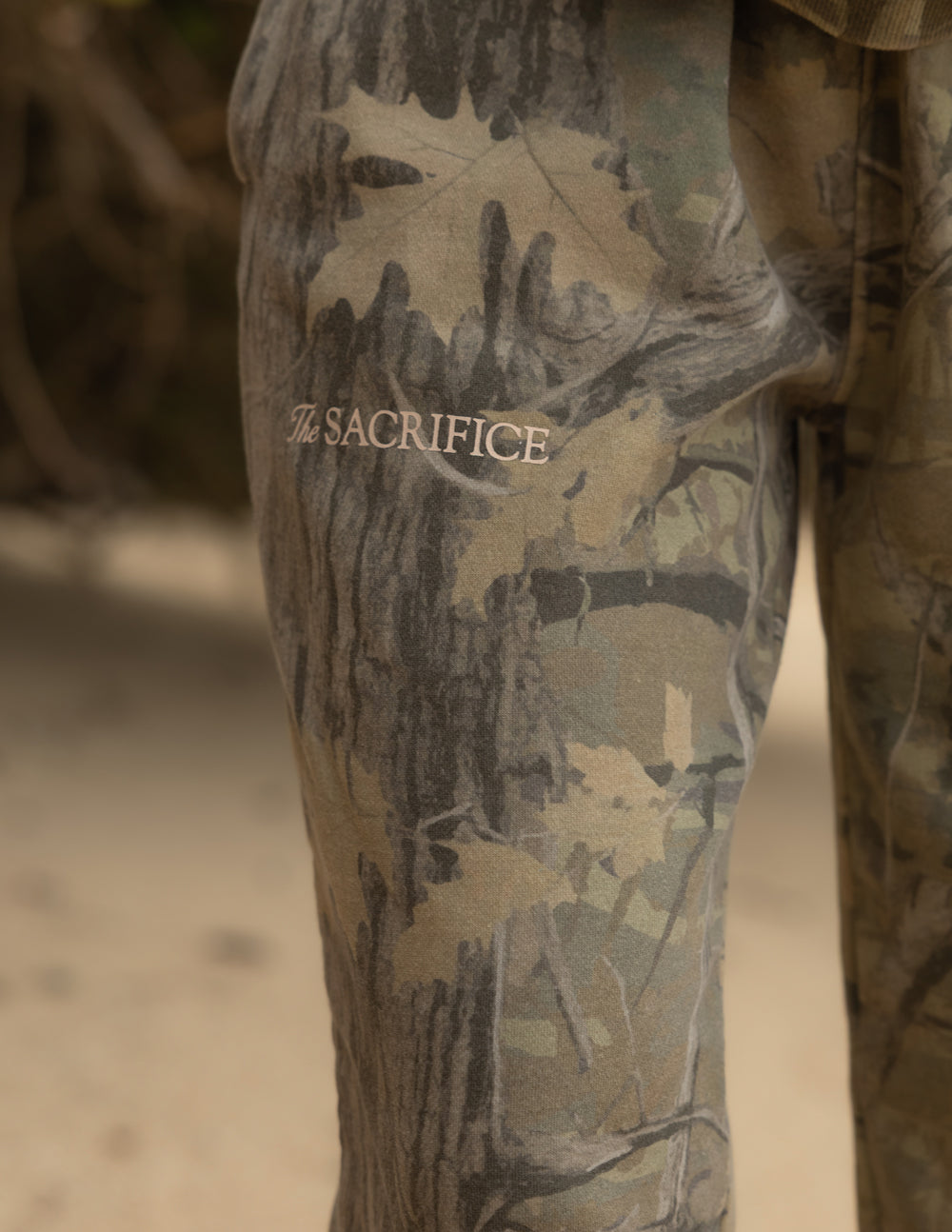 Close-up of The Sacrifice lettering on the camouflage sweatpants.