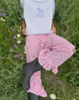 Front detail of the Petal Purple Try With God tee styled with pink gingham pants