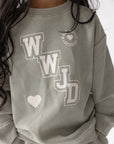 Close-up of WWJD varsity graphic on Forest Fog kids’ sweatshirt