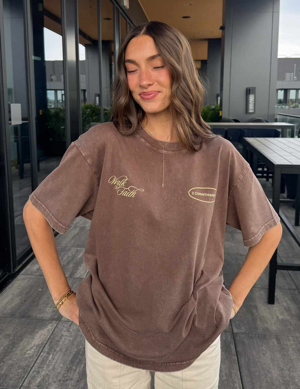 Woman wearing the Carafe brown Walk by Faith oversized T-shirt with light pants indoors