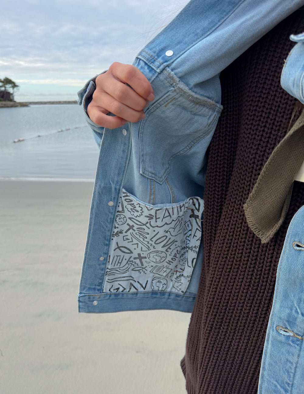 Inside pocket lining of the What a Friend in Jesus Denim Jacket featuring illustrated artwork