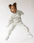 Child jumping in the What a Friend in Jesus white camo hoodie with coordinating pants