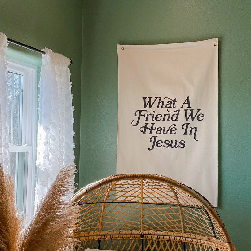 Decorative banner with text on a green wall next to a window with white curtains.