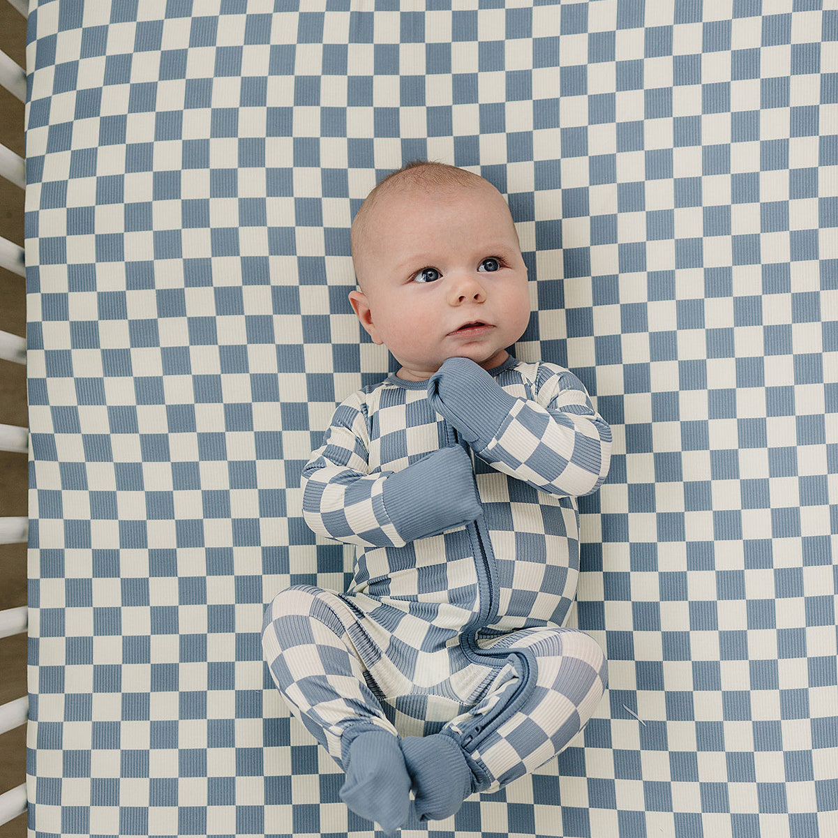 Baby lying on a blue and white checkered blanket
