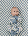 Baby lying on a blue and white checkered blanket