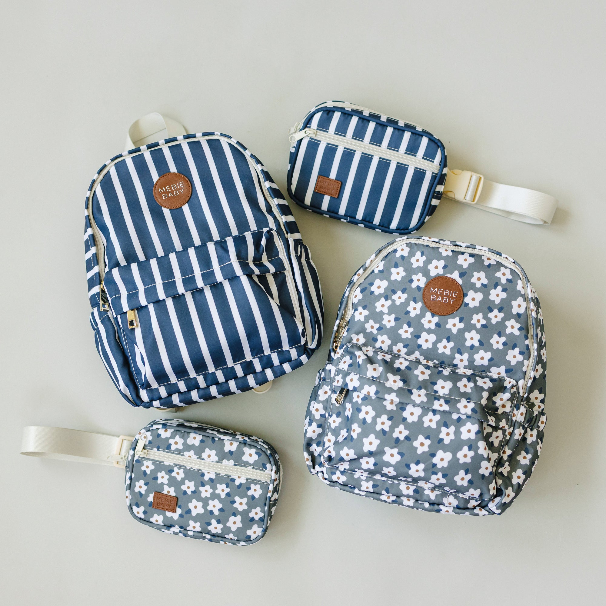 Set of blue patterned bags including a backpack, crossbody bag, and pouch on a light gray background.