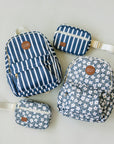 Set of blue patterned bags including a backpack, crossbody bag, and pouch on a light gray background.