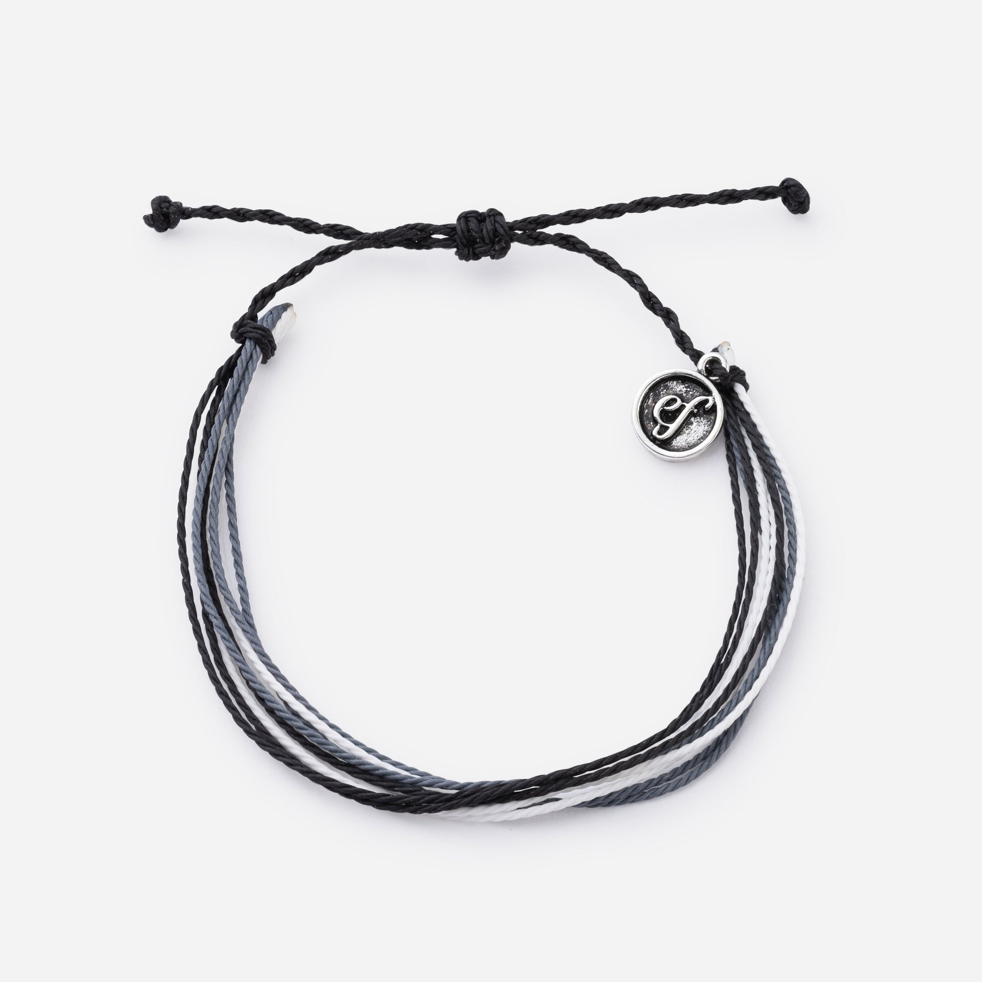 Black braided bracelet with a silver charm on a white background