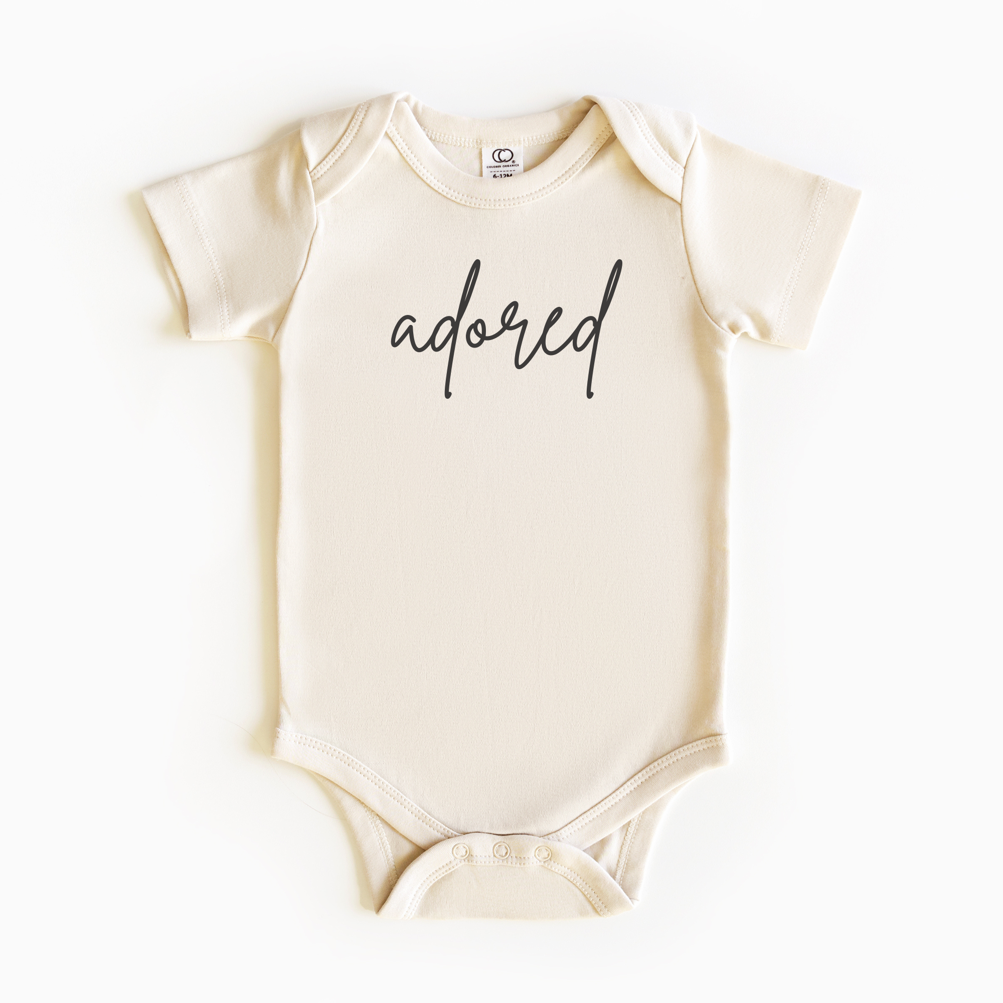 Baby wearing “Adored” affirmation bodysuit – Christian script design organic cotton outfit by Lumiere Vive