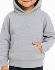 Toddler girl wearing a heather gray Bella Canvas 3719T sponge fleece hoodie, front view, neutral background, ideal for custom printing