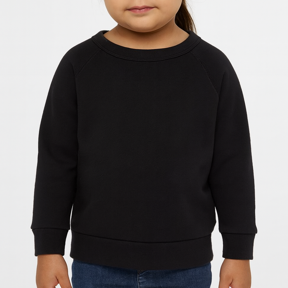 Toddler girl wearing a black BELLA + CANVAS 3901T sponge fleece raglan crewneck sweatshirt, front view, neutral background