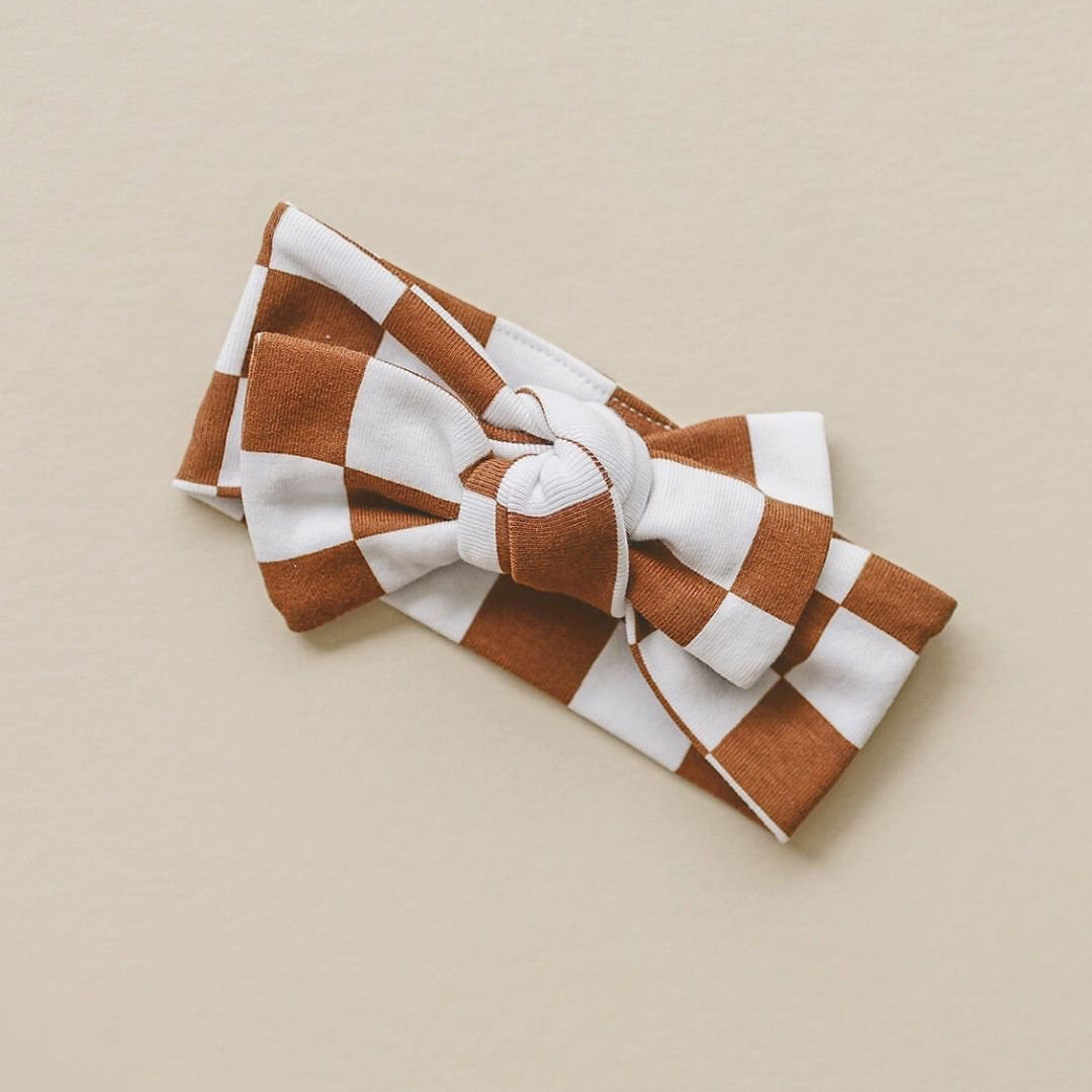 Brown and white checkered headband on a beige background