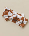 Brown and white checkered headband on a beige background