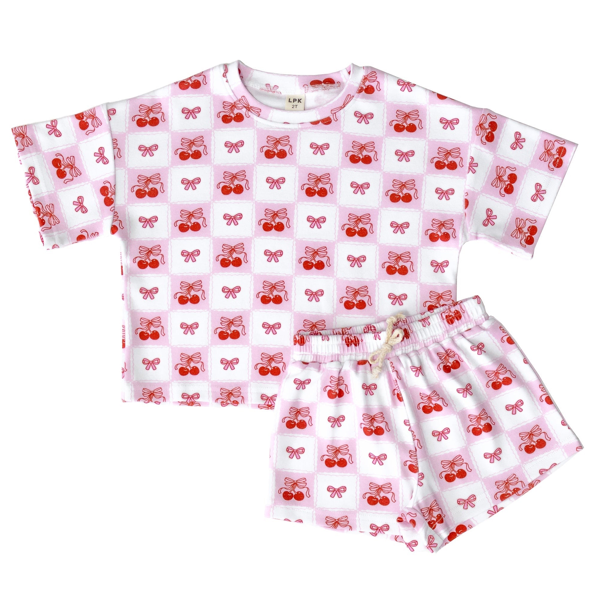 Children's pajama set with red cherry pattern on a white background