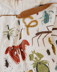 Child lying on a blanket with insect illustrations on a white background