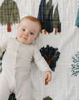 Baby lying on a quilt with tree pattern