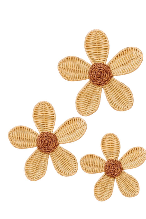 Three woven flower-shaped objects with brown centers on a white background