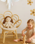 Child playing with a wooden toy in a room with a decorative elephant head and floral wall stickers.