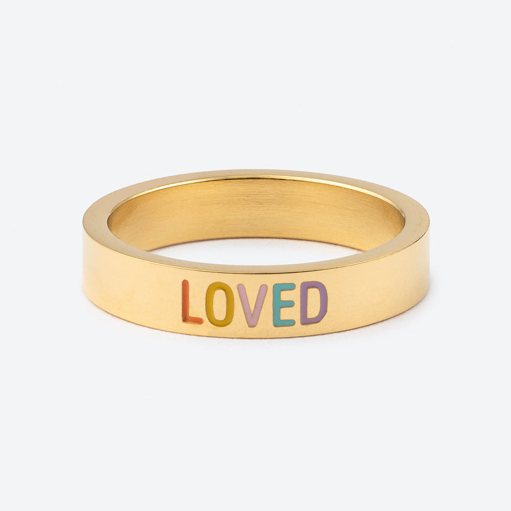 Gold ring with 'LOVED' in colorful letters on a white background