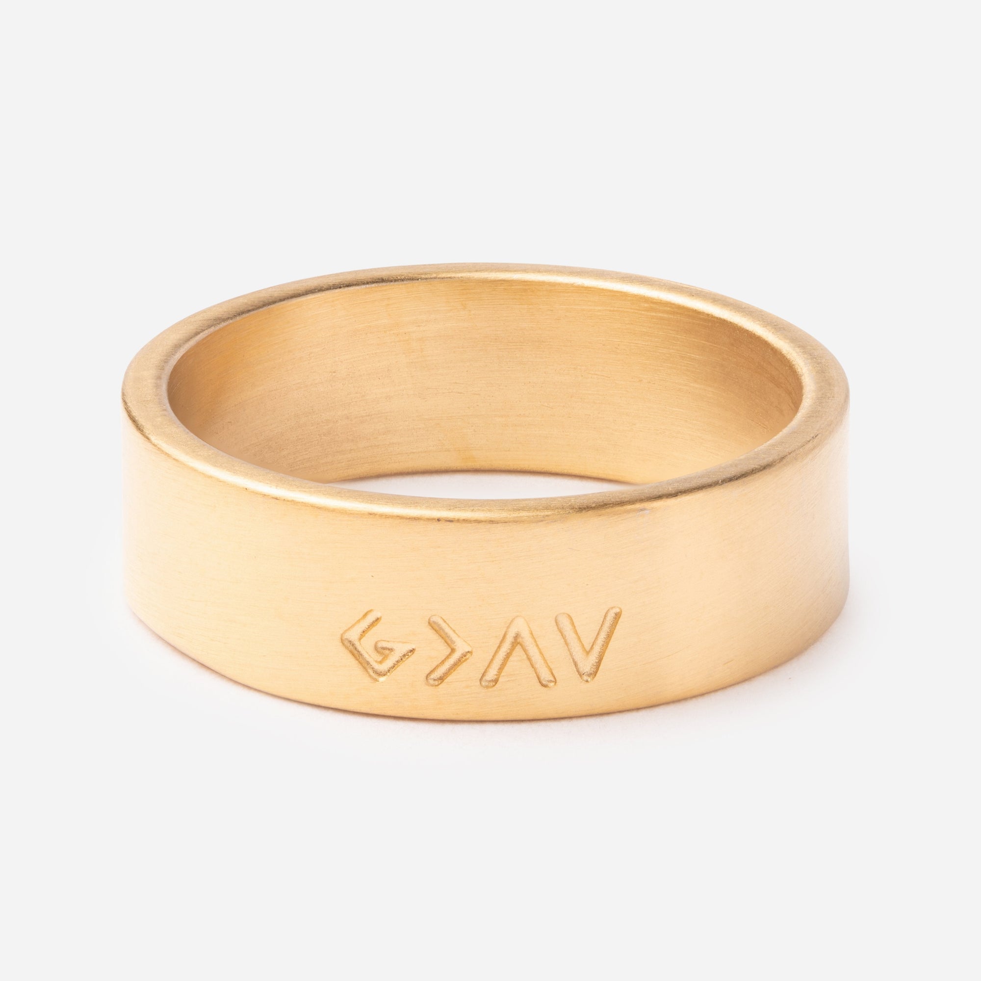 Gold ring with engraved design on a white background