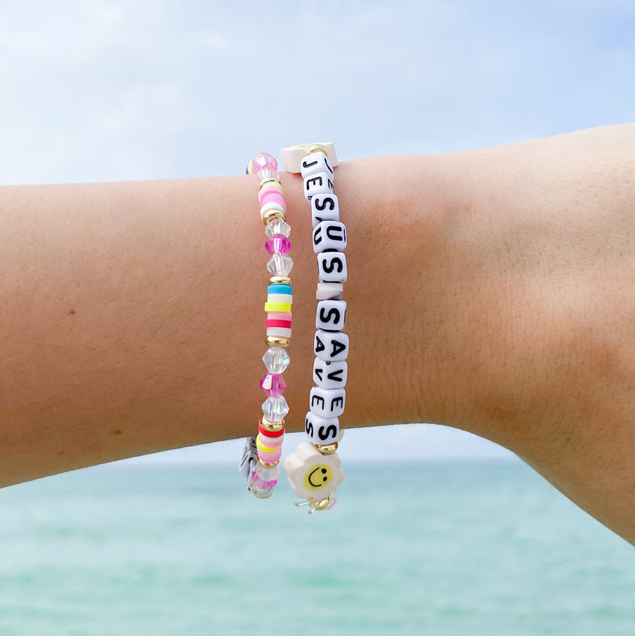Two bracelets on a wrist with a clear blue sky background
