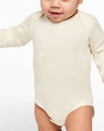 Infant wearing a natural Rabbit Skins 4421 fine jersey long sleeve bodysuit, front view, ideal for custom printing