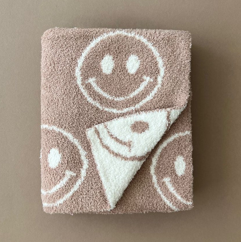 Towel with smiley face patterns on a brown background