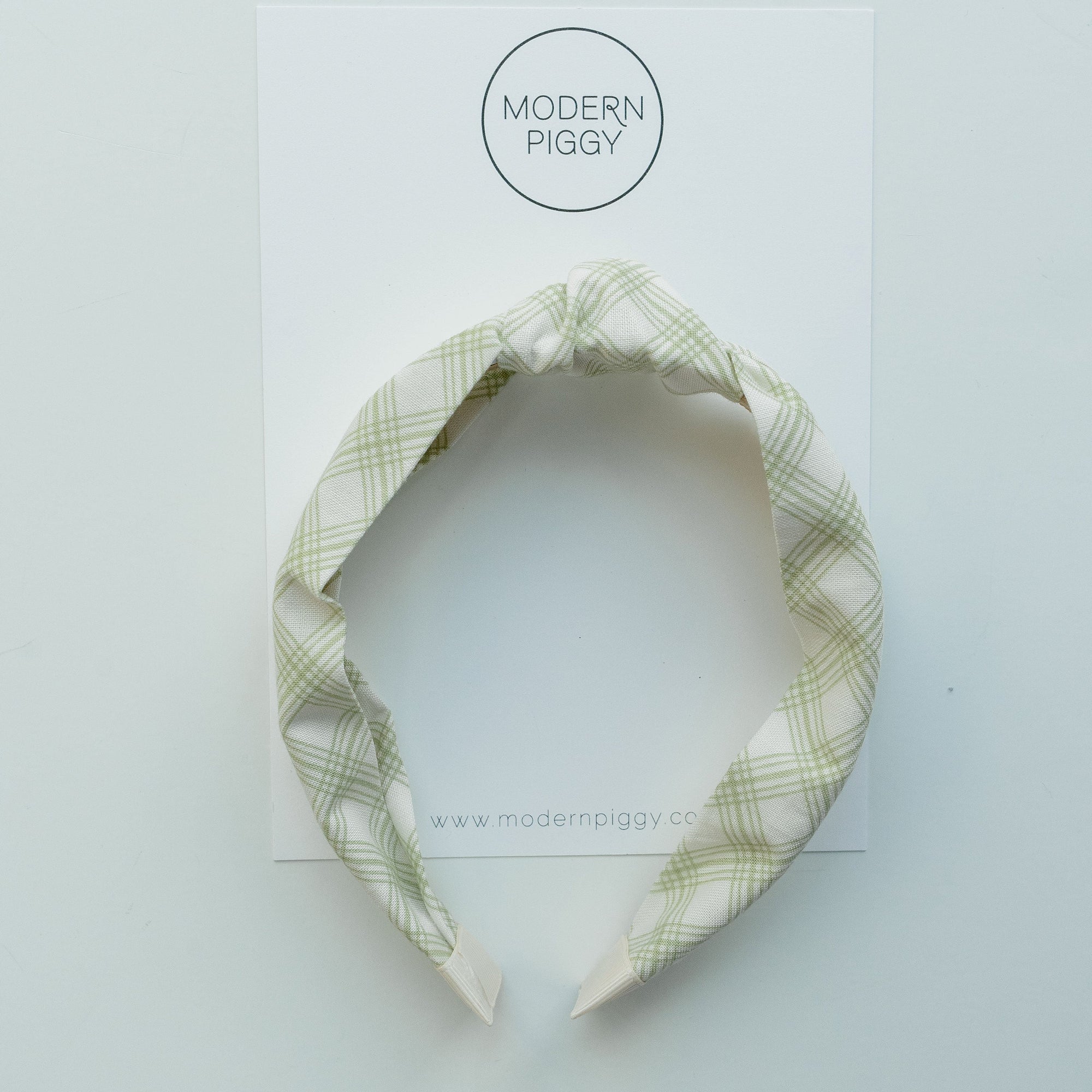Green plaid headband on a white background with 'Modern Piggy' branding.